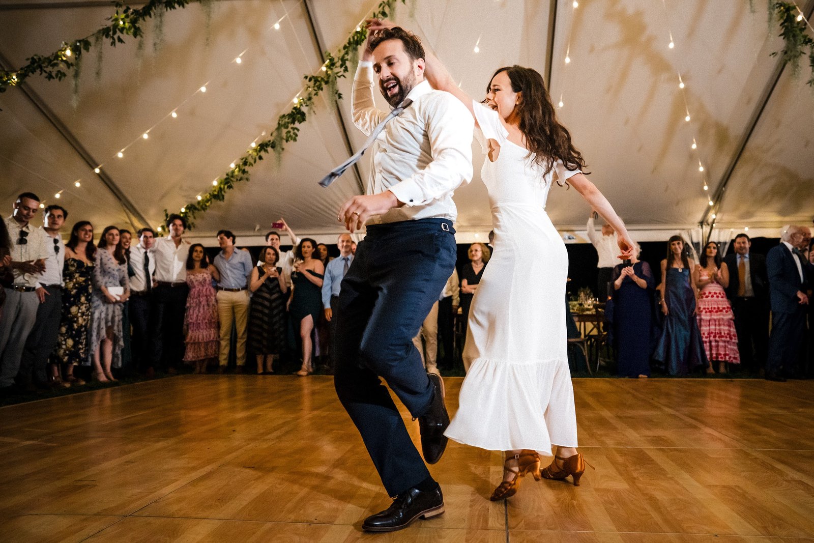 Couple dancing energetically on a dance floor at an outdoor tented Oklahoma City reception